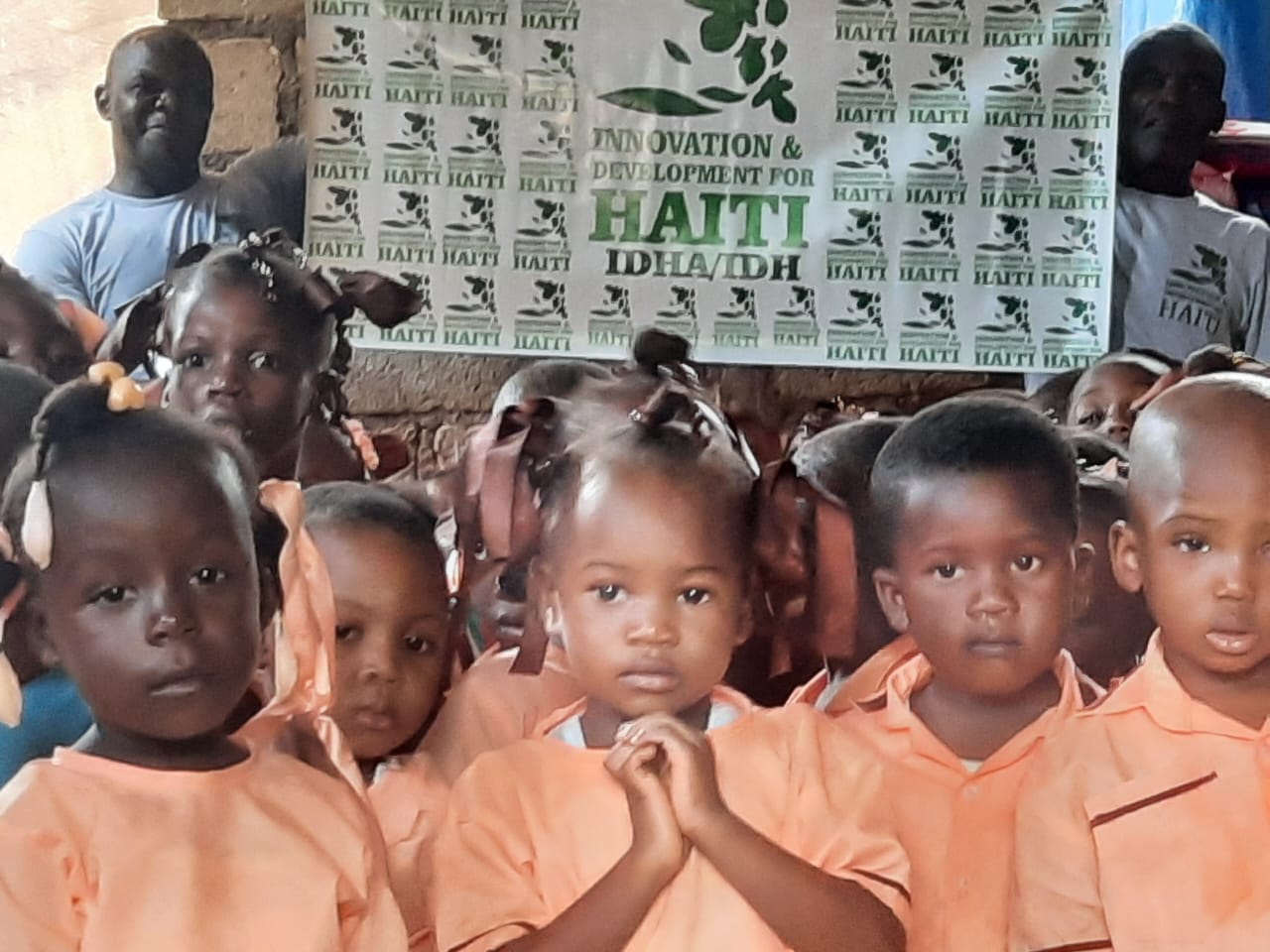 Haitian children in school holding IDH sign